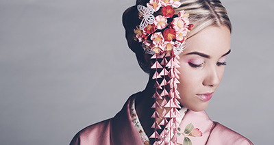 Young woman wearing a pink kimono and cherry blossom hair accessory